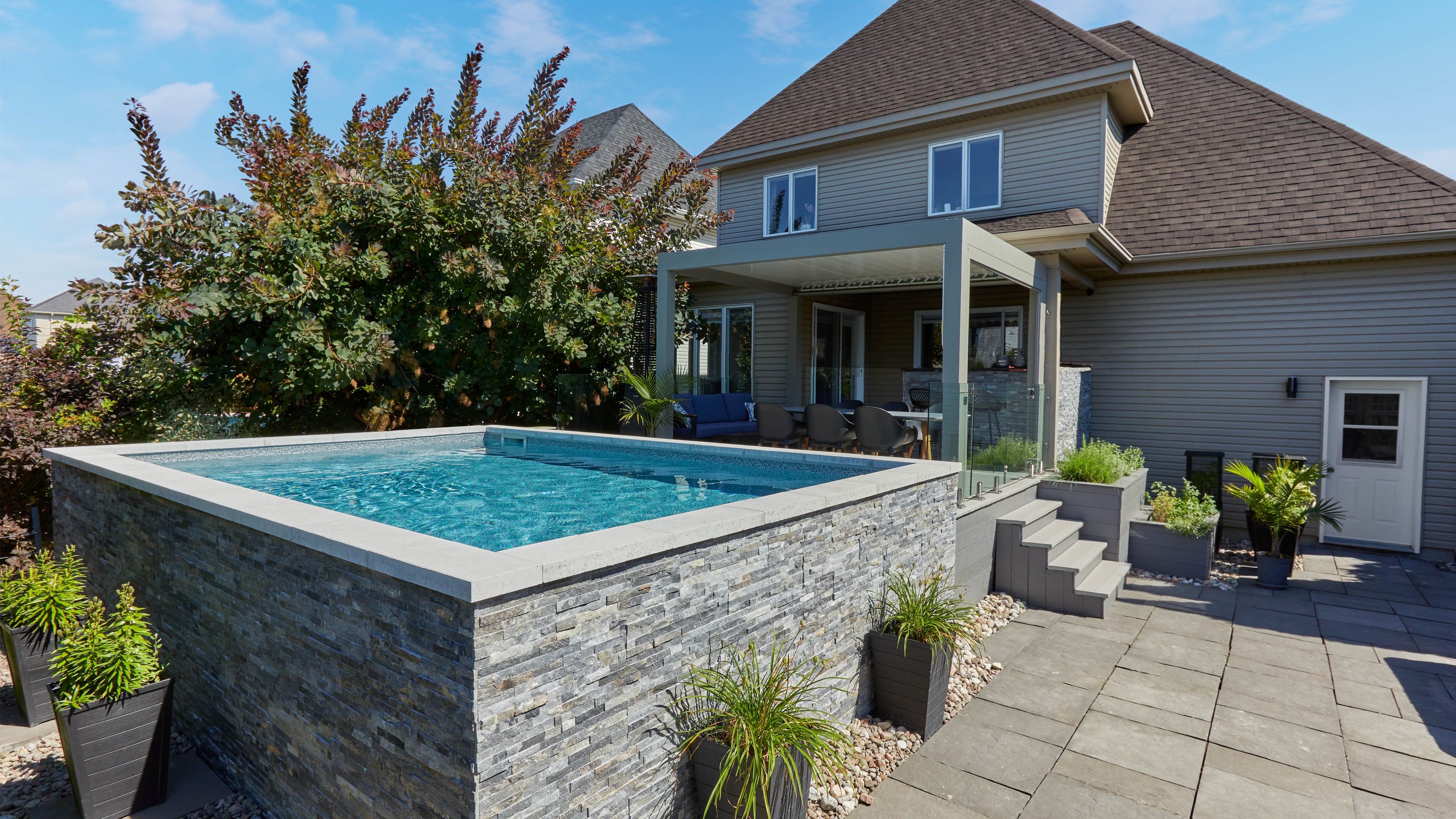 Trevi Futura | 12′ x 18’ Finlandaise shape | Basque liner| Rio natural stone siding | Liner-covered corner steps